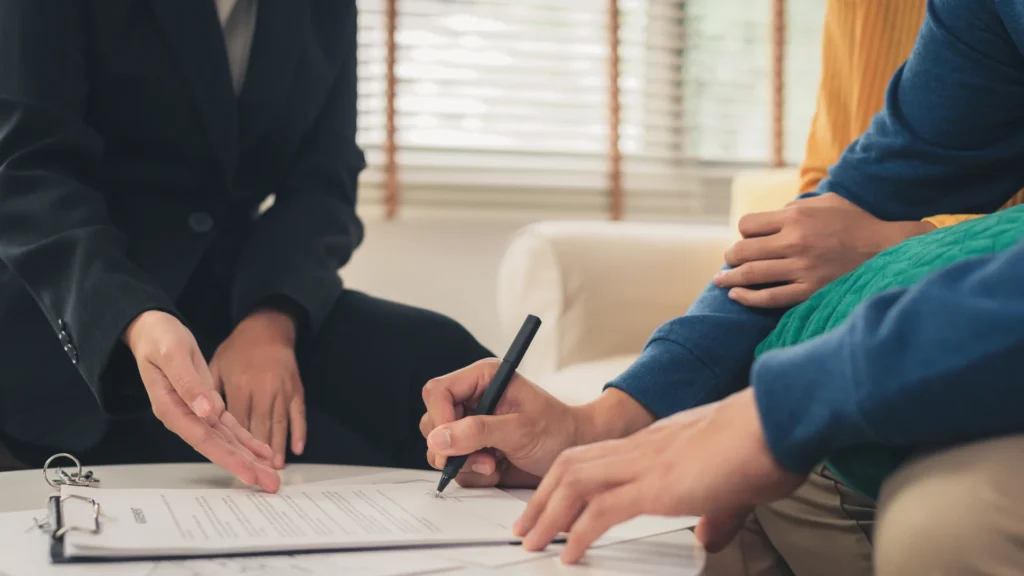 Man and woman signing an agreement with a realtor agent