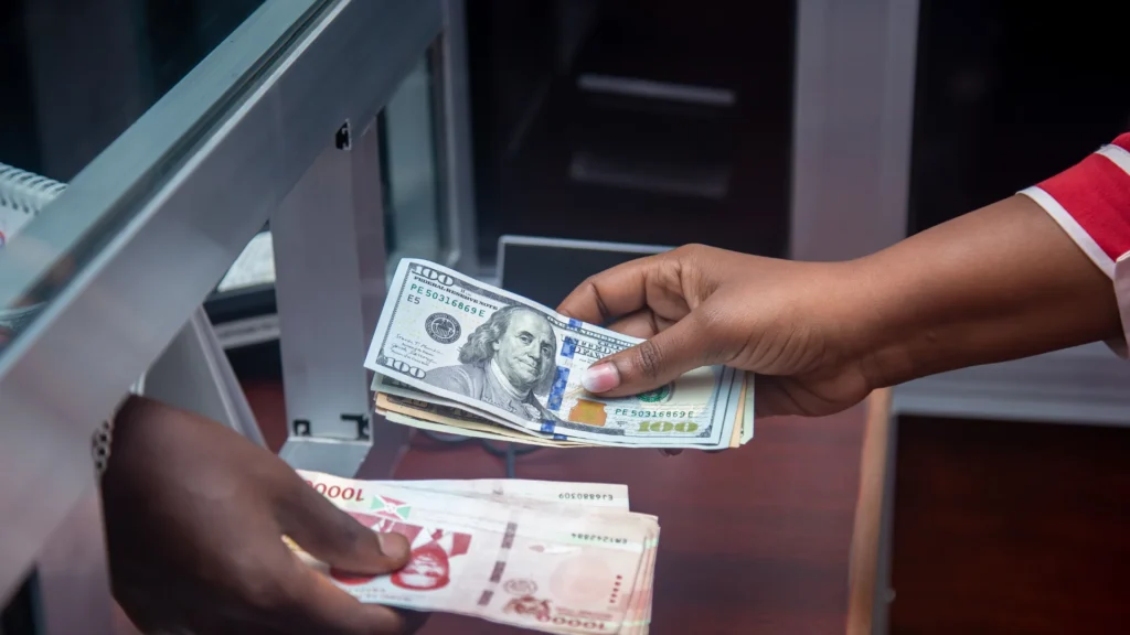 A bank officer and a bank customer exchanging currency at the counter